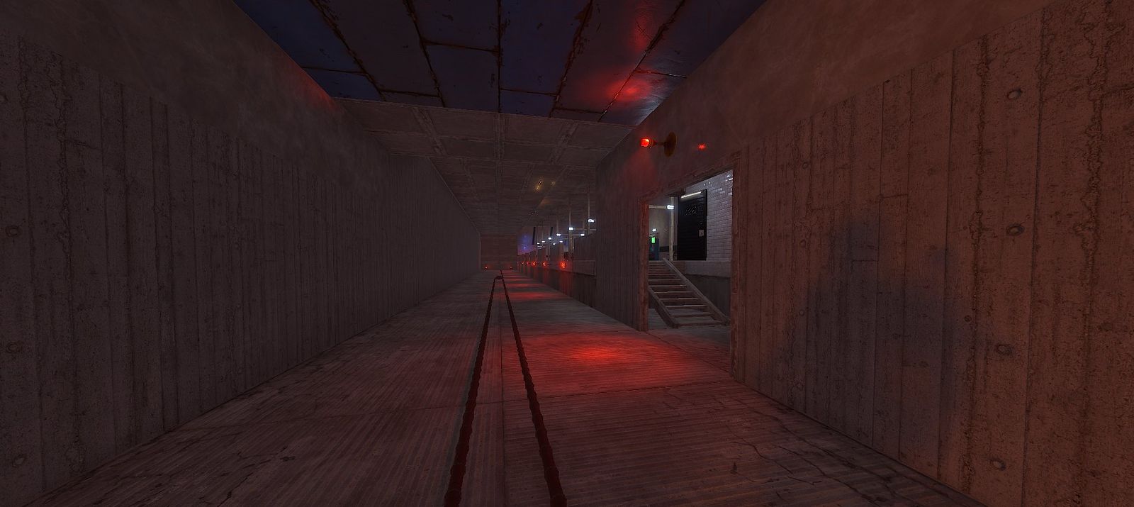 Subway factory: a long concrete tunnel with rails, red warning lights and a doorway to a tiled stairwell