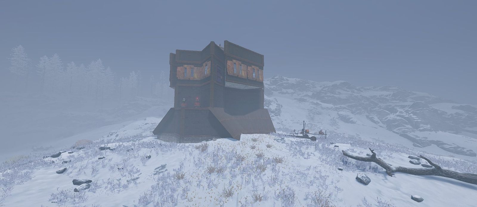 A dark metal Raidable Base on a snowy hilltop in the fog